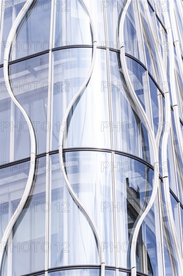 Stunning modern architecture showcasing a sleek, curved glass facade. The reflective surfaces and