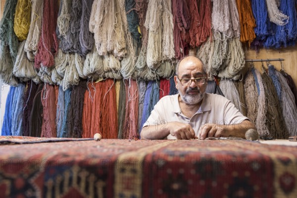 An Iranian master skillfully restores rare carpets in his well-equipped workshop in Salzburg,