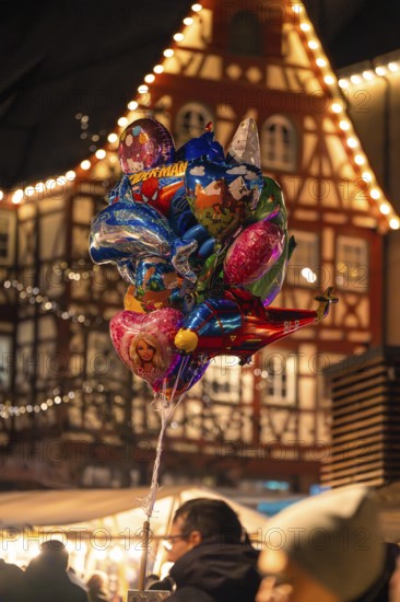 A colourful collection of balloons in front of traditional architecture at a lively Christmas