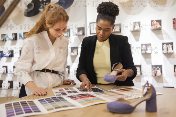 Two women discuss color options for footwear in a bridal studio. They review a color palette and