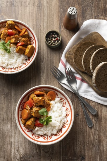 Top view of a bowl of Hungarian pork goulash served with white rice, garnished with a sprig of