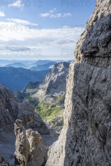 Climbers on a rock band, Bocchette Centrale band trail, via ferrata in the Brenta Mountains,