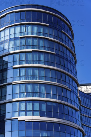 A stunning example of modern architecture featuring a curved glass facade with visible concrete and