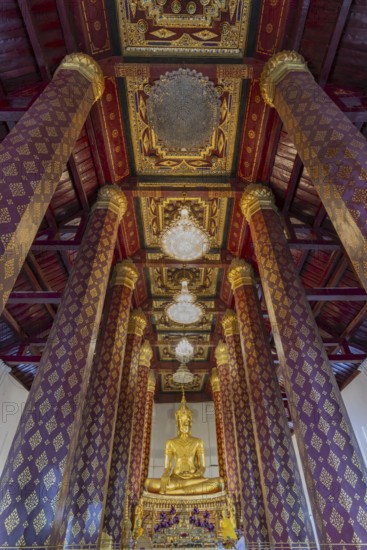 Golden Buddha statue, Phra Phuttha Nimit, and coffered ceiling in the ubosot of Wat Na Phra Men,