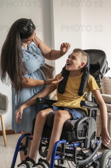 A mother lovingly cares for her son, who has cerebral palsy, sitting in a wheelchair. The scene