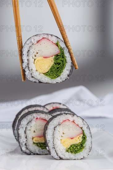 A close up view of sushi rolls with various colorful ingredients like crab, omelette, and greens