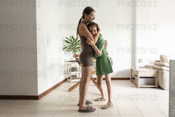 A touching moment between a young girl with a tracheostomy and her supportive sister, captured in a
