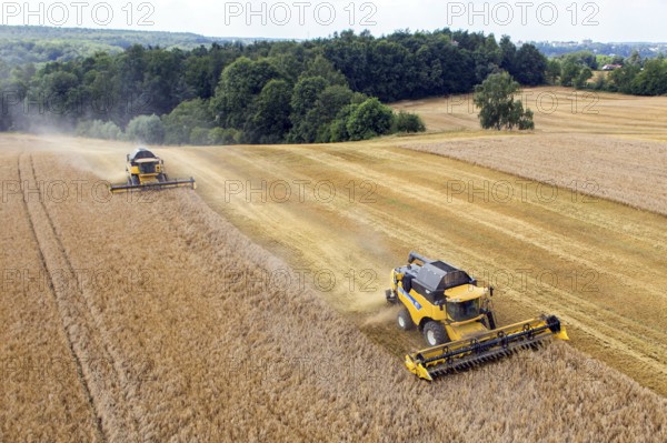 Grimma, 18.07.13 Harvesters harvesting in a field near Grimma. The picture was taken with a