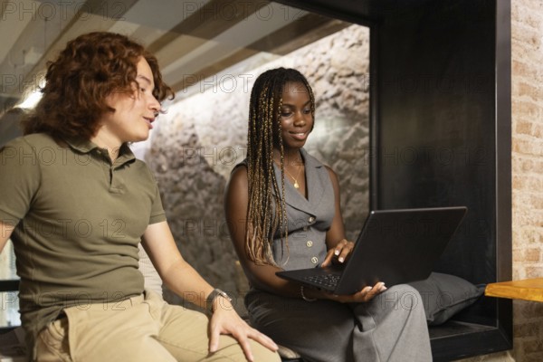 Two young professionals an African woman and a caucasian red hair man engaged in a productive