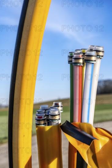 Fibre optic connection, empty conduits protrude from the ground along a dirt track, into which the