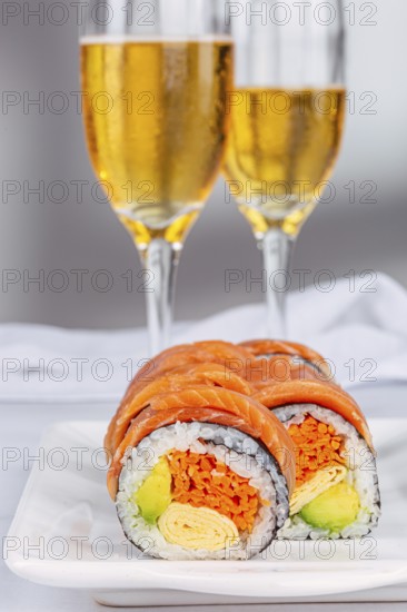 Delicious sushi rolls with salmon, avocado, and omelette are elegantly displayed on a plate,
