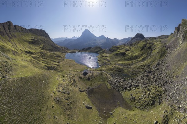 A stunning aerial view captures the tranquil Ayous Refuge surrounded by lush green landscapes and a