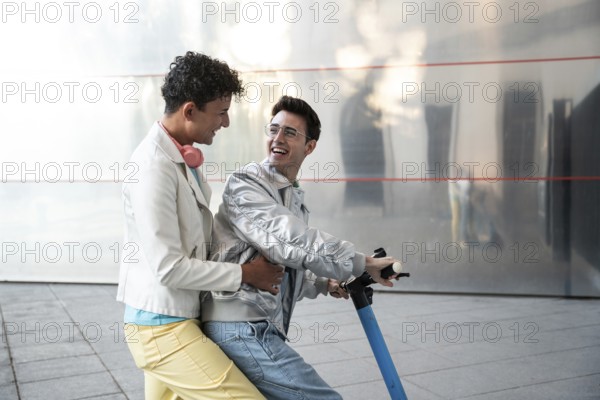 A cheerful gay couple enjoying a scooter ride together on a sunny day, wearing casual outfits.
