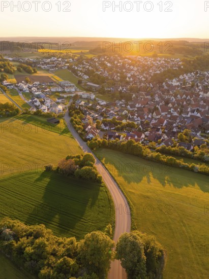 View of a village and a road surrounded by fields and trees at sunset, Gechingen, Black Forest,
