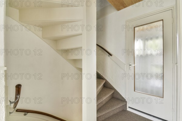 A minimalist indoor staircase with a modern design featuring light colored walls, a wooden
