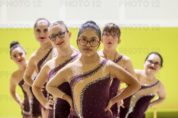 A diverse gymnastic team showcases unity and determination. Wearing matching outfits with sequins,