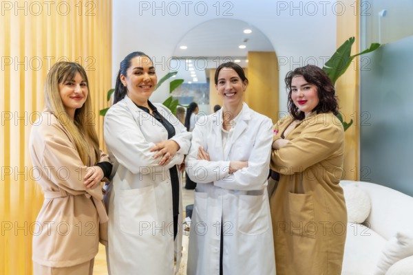 Group of confident women, including doctors and staff, standing with arms crossed and smiling at
