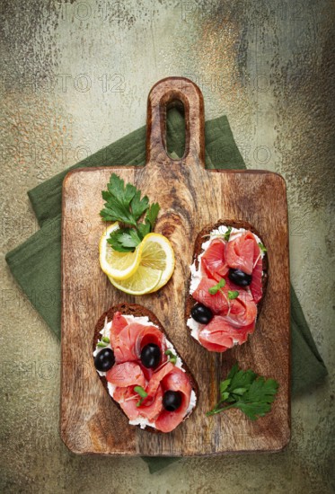 Sandwiches with cream cheese, chum salmon, cold smoked, grain bread, on a cutting board, top view,