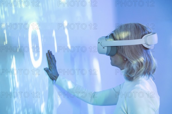 An elderly Asian woman interacts with the virtual world wearing a VR headset, symbolizing the