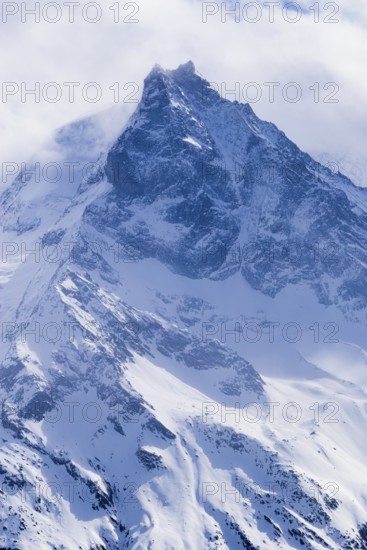 Fog envelops the snowy summit of the mountain Le Besso, Val d'Anniviers, Valais Alps, Canton