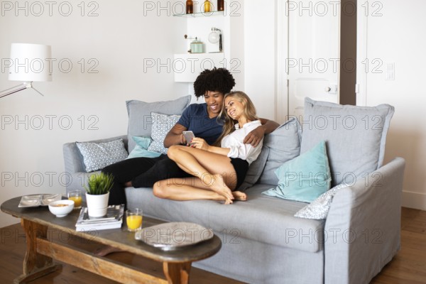A happy couple sitting on a comfortable sofa, enjoying relaxed quality time together in a modern,