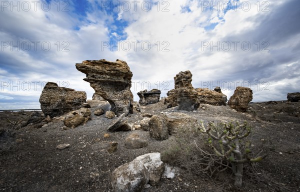 Eroded rock formations in volcanic landscape with dramatic cloudy skies, Ciudad Estratificada or
