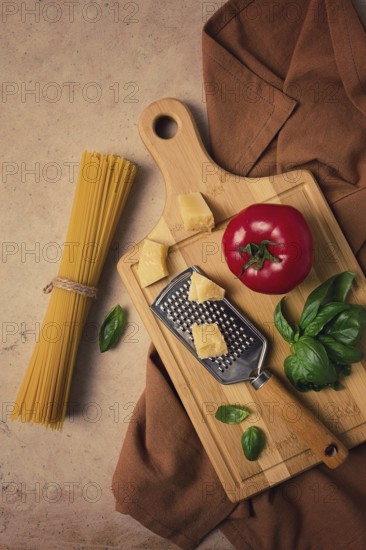 Raw pasta with ingredients on a beige background, top view, rustic style, selective focus, no