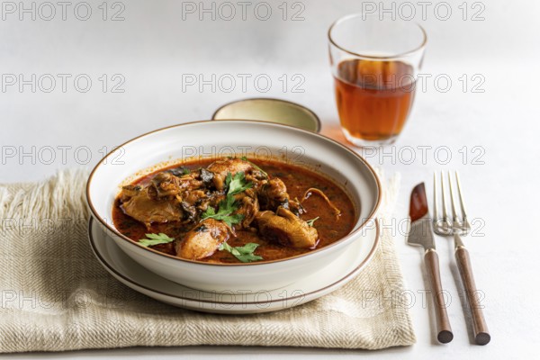 A bowl of traditional Georgian chicken stew, chakhokhbili, garnished with fresh coriander. This