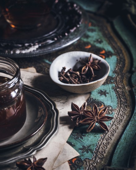 A cozy arrangement featuring a cup of tea infused with anise, presented on an ornate table. The