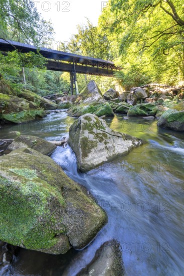 The Irrel Waterfalls, rapids in the lower reaches of the Prüm, covered wooden bridge for hikers,