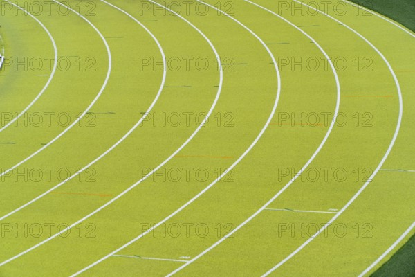 A vibrant aerial shot of a freshly marked bright green running track at an outdoor athletics
