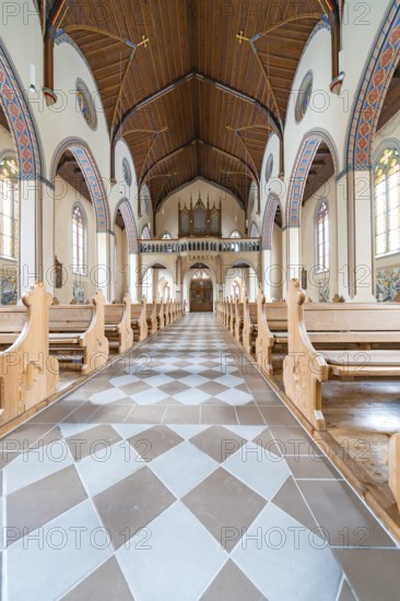 Long aisle in a church with elegant wooden benches and artistically decorated structure, Bad