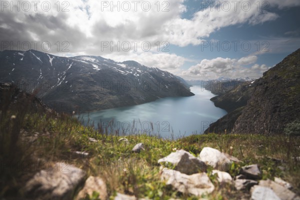 A breathtaking view of a serene turquoise lake nestled between rugged mountains in Norway The