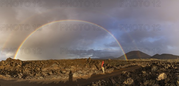 A vibrant rainbow arches over the rugged volcanic terrain of Timanfaya National Park in Lanzarote,