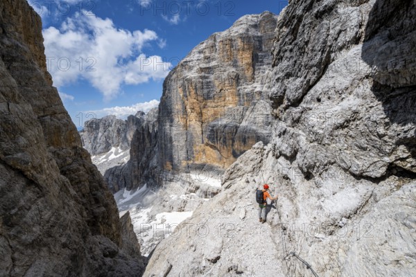 Climbers on the Via Ferrata Brentari via ferrata, spectacular mountain landscape with steep cliffs,