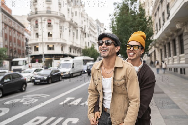 A joyful colombian gay couple enjoying a casual city walk. Both are wearing sunglasses and