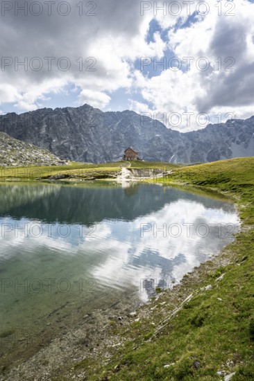 Rocky mountain peaks of the Panargenkamm and mountain hut Neue Reichenberger Hütte, mountain lake