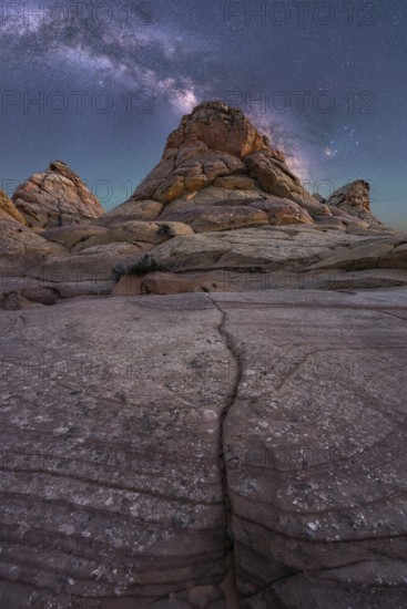Captivating image of rugged desert rock formations beneath a vibrant Milky Way in Coyote Buttes,