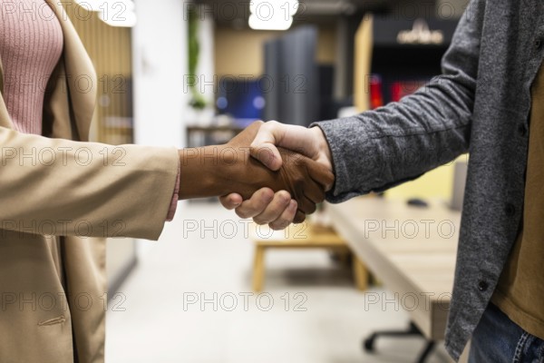 Two people are shaking hands in a modern office. The image captures the essence of professionalism,