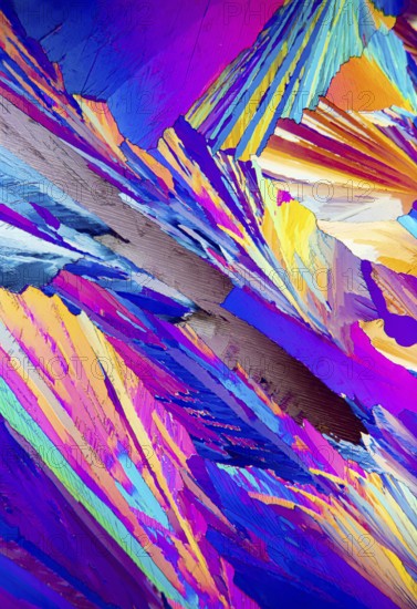 This striking image depicts the colorful patterns of Adipic acid crystals under a microscope,