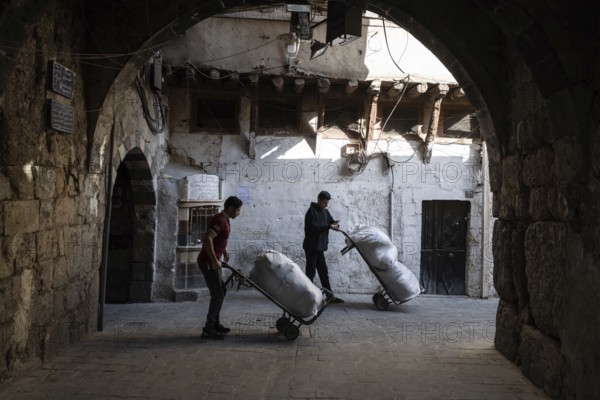 Damascus, Syria. December 4th 2025. Young Syrian men working in the narrow streets near Al