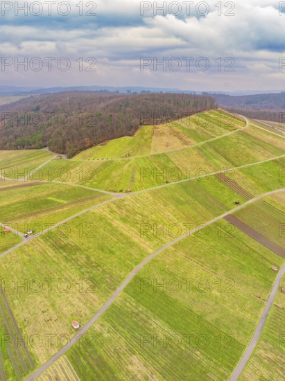 Aerial view of green fields and roads in hilly terrain under a cloudy sky, Großbottwar, Ludwigsburg
