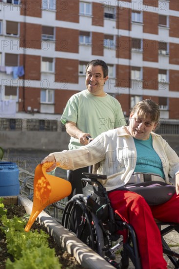 Two individuals at a day center participate in gardening, nurturing plants in an outdoor garden.
