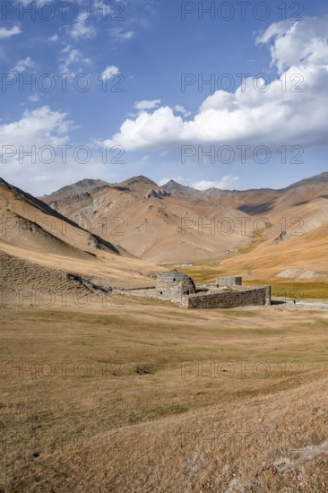 Historic caravanserai Tash Rabat from the 15th century, with yellow hills, Atbashy district in the
