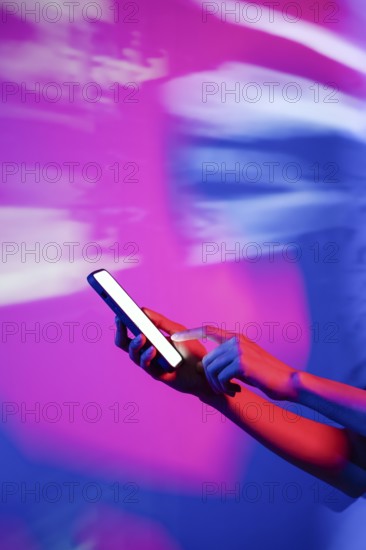 A hand interacts with a smartphone illuminated by vibrant neon lights, creating a modern and