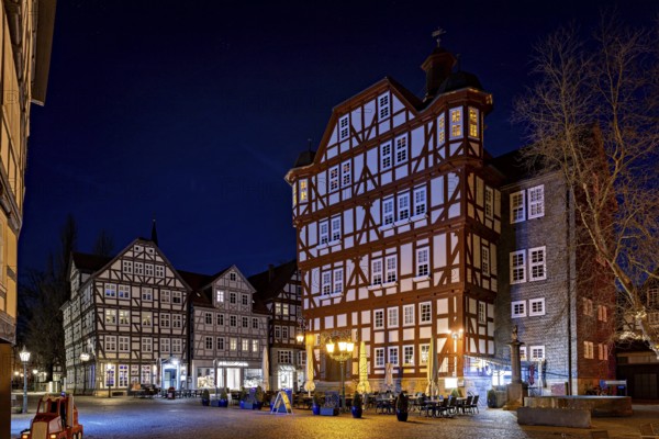 Impressive half-timbered houses in their nocturnal splendour with lights on a quiet square, The