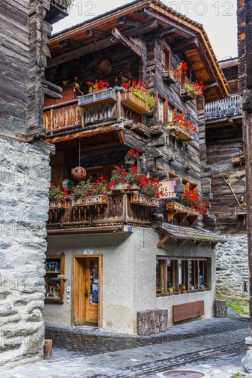 Old house decorated with flowers in the historic village centre, Grimentz, Val d'Anniviers, Valais