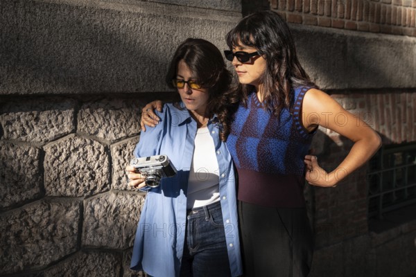 A multiethnic lesbian couple enjoys a moment together outdoors. One embracing the other while they