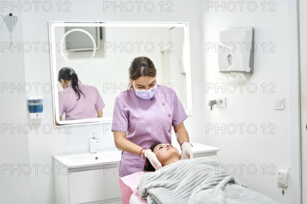 A skilled professional administers a beauty treatment to a client in a clean, modern aesthetic