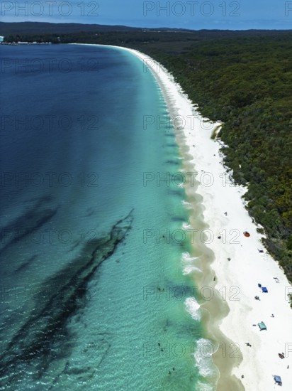 Aerial view of a pristine beach with vibrant turquoise waters and white sand in Jervis Bay,